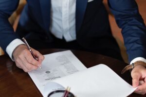 A professional signing legal documents at a desk